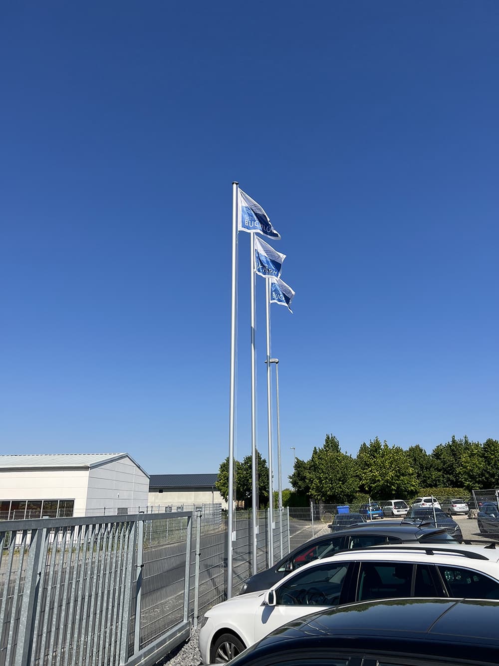 The company is expanding and raises its flags in Bruchhausen in front of their new office.